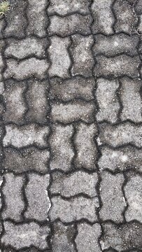 Top view of interlocking concrete pavers forming a textured grey pathway surface
