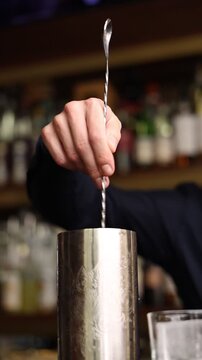Bartender preparing a craft cocktail in a premium luxury restaurant. Close-up shots of mixing, pouring and garnishing. Elegant bar atmosphere, professional mixology, nightlife concept.