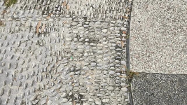 Close-up of textured pebble path with grey concrete border