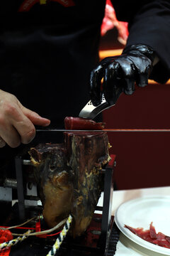 maestro cortador cortando cecina de una paleta de cecina curada
