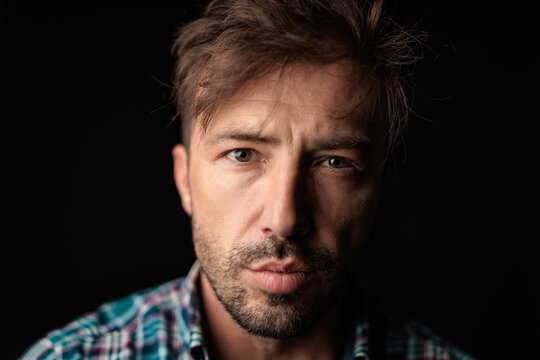 Serious bearded man with messy hair and plaid shirt