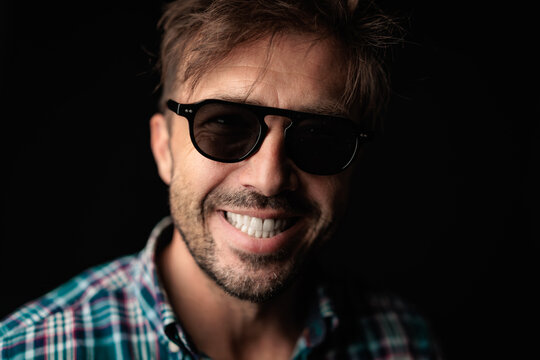 Cheerful man smiling with casual checkered shirt and sunglasses