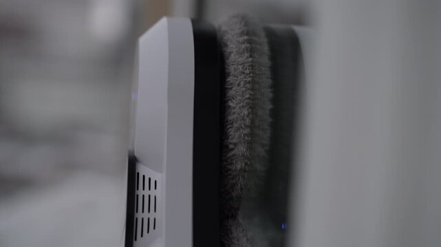 Close-up of robotic window cleaner with microfiber cloth moving automatically on large glass surface. Concept of modern smart home technology for efficient and convenient household maintenance.