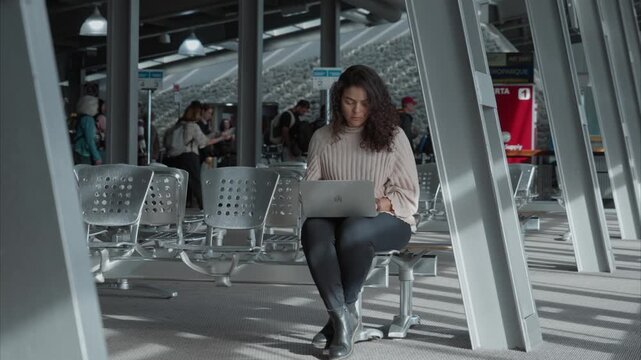 Woman Working on Laptop at Airport Terminal