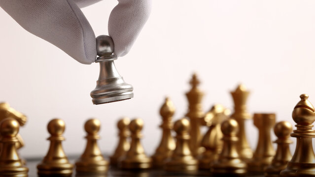 Chess board. Close up chesses strategy concept of silver and gold chess on classic board. Hand carefully moves a piece symbolizing planning decision making leadership competition tactics and success.