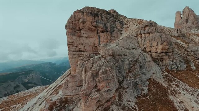 FPV drone flying along the surface of mountain cliffs of Cristallo mountain.