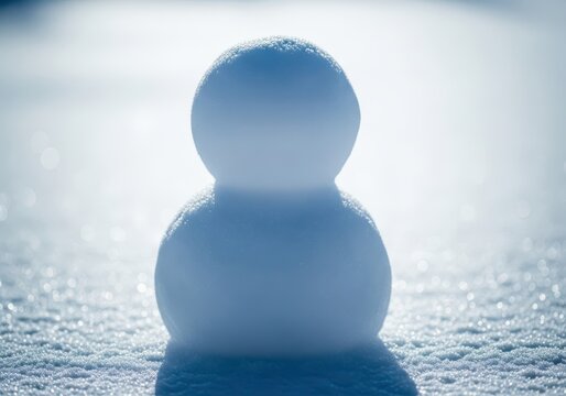 A slightly slumped snowman standing in bright late winter sunlight, with drops of water forming on the surface of the melting snow, seasonal, simple, garden