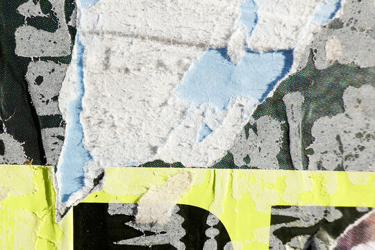 Old colorful ripped torn grunge advertising posters on wall background
