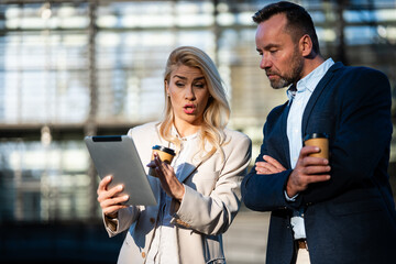 Business colleagues discussing data on tablet outdoors © Zoran Jesic