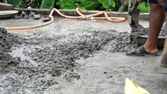 Manual Laborer Spreading Liquid Concrete Aggregate at Home Building Site. Close Up of Wet Cement and Shovel Tool in Action at Construction Work.