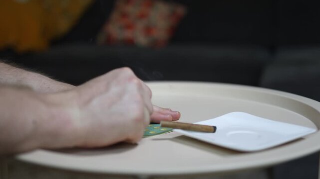 Close up of hands scratching a lottery ticket beside a smoking joint capturing gambling addiction risky behavior false hope and compulsive habits