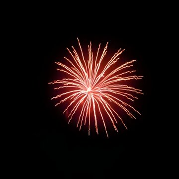 Single Bright Red Firework Burst Isolated on a Black Night Sky Background
