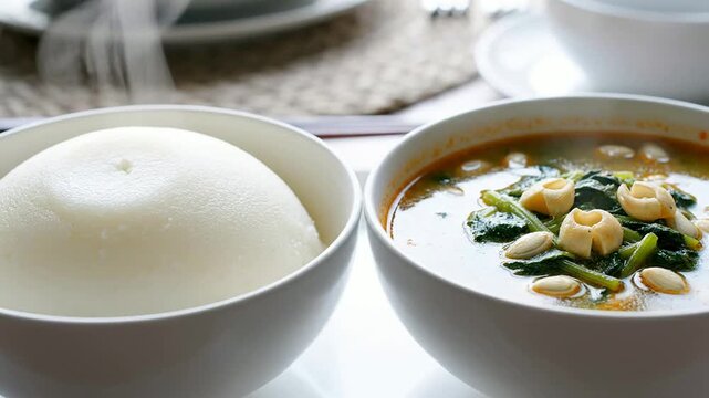 Close Up Of Steaming Pounded Yam Next To A Bowl Of Flavorful Egusi Soup Celebrating Traditional Nigerian Cuisine