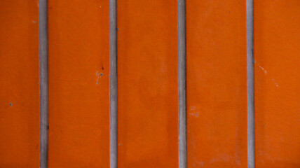 Fototapeta premium Vibrant Orange Wall Texture With Vertical Gray Dividers
