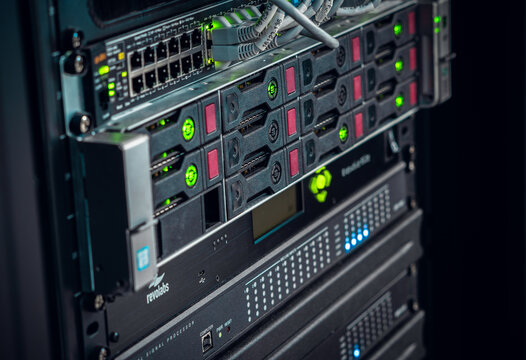View of a server rack with networking equipment, blinking green status lights, and storage drives in Los Angeles, California, United States.