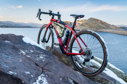 lightweight gravel bike on a rocky cliff overlooking a mountain lake - winter dusk over Horsertooth Reservoir in Fort Collins, Colorado