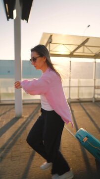 Caucasian woman pulling a suitcase and running, late for flight