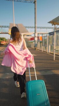 Caucasian woman pulling a suitcase and running, late for train.