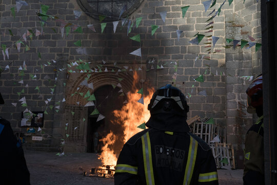 Traditional midsummer bonfire burning brightly outside the historic Church of San Juan Bautista during the Night of San Juan festival in Avila, Castile and Leon, Spain.