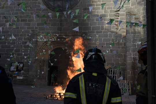 Traditional midsummer bonfire burning brightly outside the historic Church of San Juan Bautista during the Night of San Juan festival in Avila, Castile and Leon, Spain.