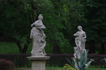 Obraz premium Classical garden statues in a historic park during an outdoor event / Baroque statues of Bacchus and Bacchante in Mieroszewski Park, Będzin 