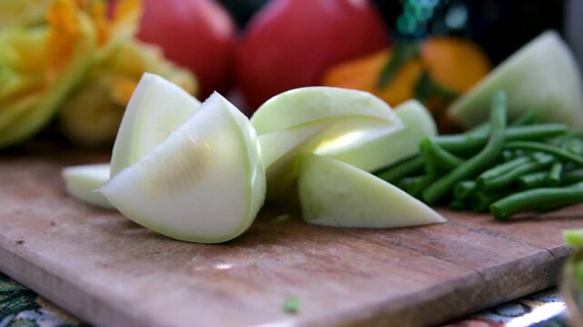 Clean pattypan squash, cucumbers, green beans, tomatoes, and young zucchini are sliced in warm sunlight, promoting healthy eating, hygiene, and careful preparation of organic homemade food. 