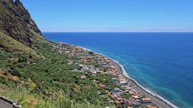 Coastal village of Paul do Mar from the Miradouro do Precipicio viewpoint, Madeira, Portugal, aerial panning shot.