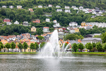 Naklejka premium Fountain sprays water in calm lake center