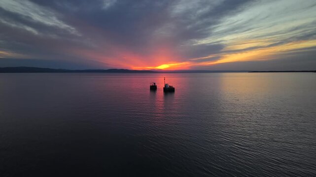Flying over structures in Lake Champlain in Burlington at sunset with the Adirondack Mountains in the distance