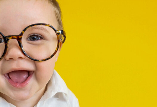 Close-up of Cute Baby in Adult Glasses with Yellow Copy Space