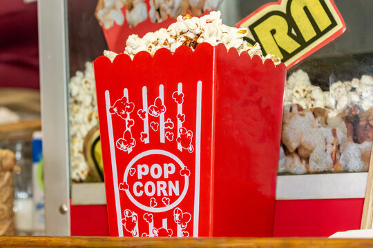 Saco de pipoca vermelho cheio de pipoca doce e fresca em m&aacute;quina de pipoca