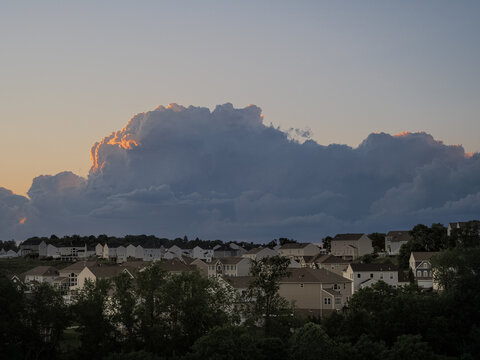 Massive thunderhead storm cloud looming behind a Pennsylvania residential suburb