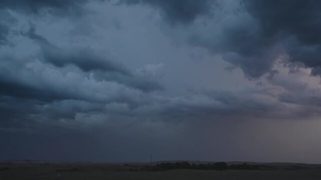 Dramatic lightning flickers through heavy night thunderclouds
