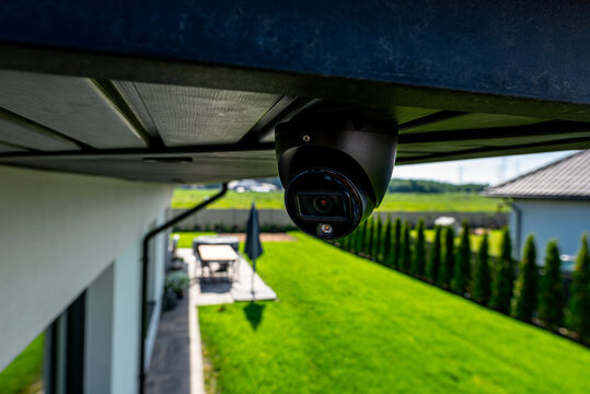 Dome security camera monitoring modern home backyard