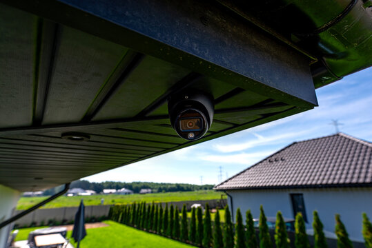 Security dome camera monitoring outside luxury modern house