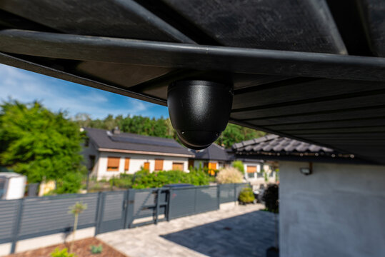 Security surveillance dome camera monitoring modern home yard