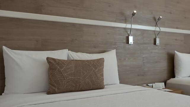Close up of a beautifully made bed featuring clean and elegantly arranged pillows
