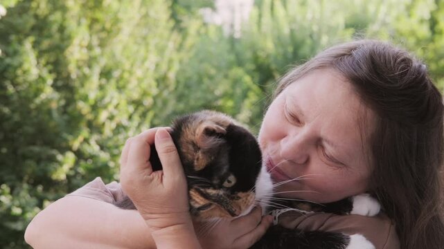 plus size woman holding calico cat, tortoiseshell feline, hugging pet and care, Human animal bonding friendship, furry friend, animal lover, casual clothing, domestic kitten, warmth and trust