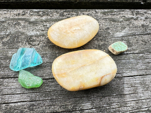 Smooth pebbles and colorful sea glass on weathered wood