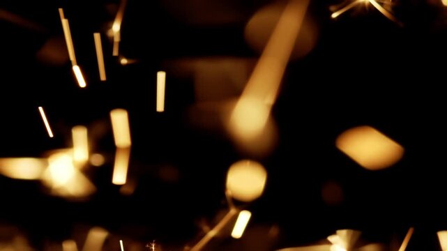Macro of glowing hot embers burning off and sparking. Close up of fast exploding sparks flying. Pyrotechnic display of intense exploding pyrotechnics.