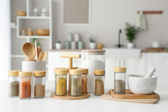 Organized kitchen spices and utensils on white countertop
