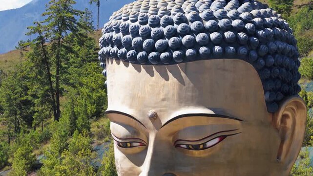 Aerial view of the massive golden Buddha Dordenma statue set against a lush green hillside in Thimphu, Thimphu, Bhutan.