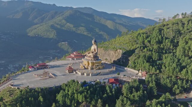 Aerial view of the giant Buddha Dordenma statue overlooking the lush green mountains and valley in Thimphu, Thimphu, Bhutan.