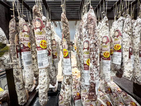PRIVAS, FRANCE - OCTOBER 4, 2025: French saucisson d'Ardeche hanging in a supermarket in Privas, France, dry-cured pork sausages, on retail packaging and regional Ardechoise food culture.