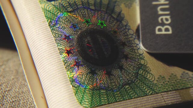 A close-up of the illuminated holographic emblem of the EU Schengen visa. The iridescent multicolor security hologram of the Schengen visa of the European Union countries. 4k slow motion video 60 fps.
