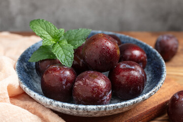 Fresh purple plums on the desktop © 张苏云 张