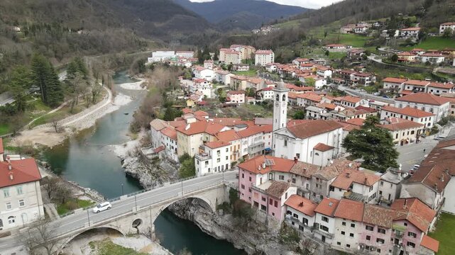 Aerial view of the historic town of Kanal ob Soci with its stone bridge over the emerald Soca river, surrounded by lush hills in Kanal ob Soci, Nova Gorica, Slovenia.