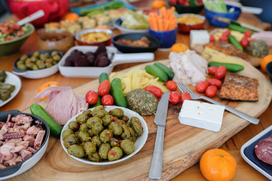 Mezze Appetizer Brunch Charcuterie Olives Mediterranean Food platter featuring fresh vegetables, cheese, smoked salmon, and gourmet snacks on a rustic wooden board for a party.
