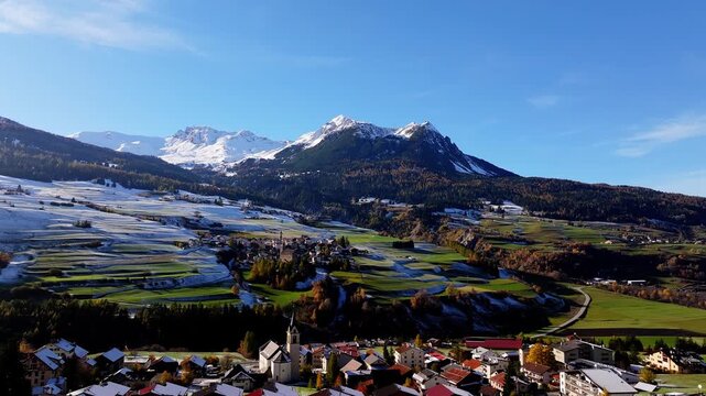 Aerial view of Riom Castle overlooking the village of Surses nestled in the snowy mountains of Surses, Graubunden, Switzerland.