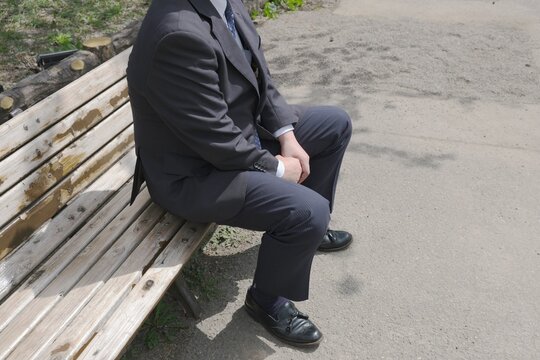 公園のベンチで一人座り込む男性